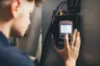 Techniker bedient Steuerungseinheit mit Touchscreen an Heizsystem