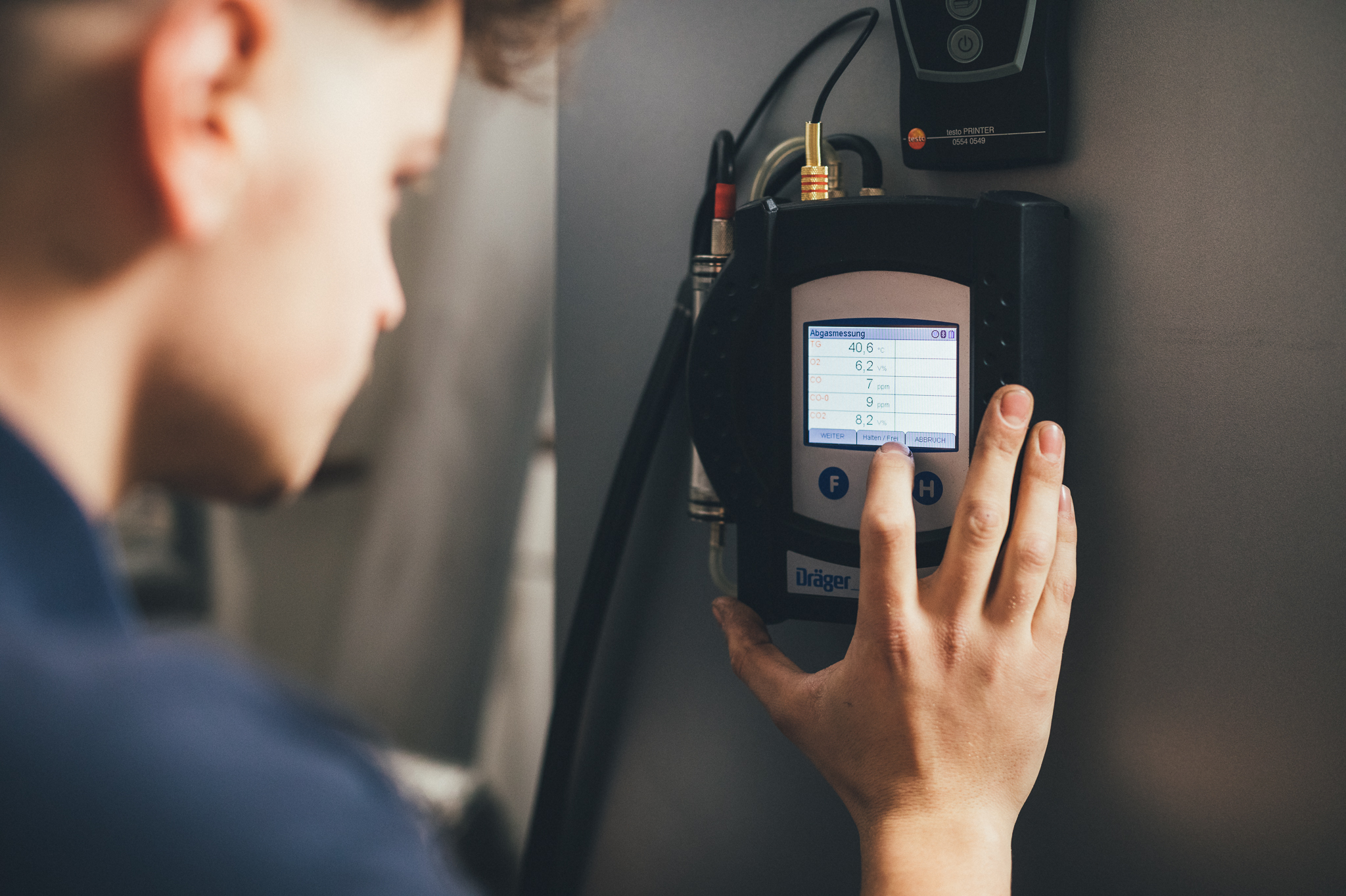 Techniker bedient Steuerungseinheit mit Touchscreen an Heizsystem