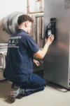 Techniker der Firma Eckhardt bedient Heizungssteuerung