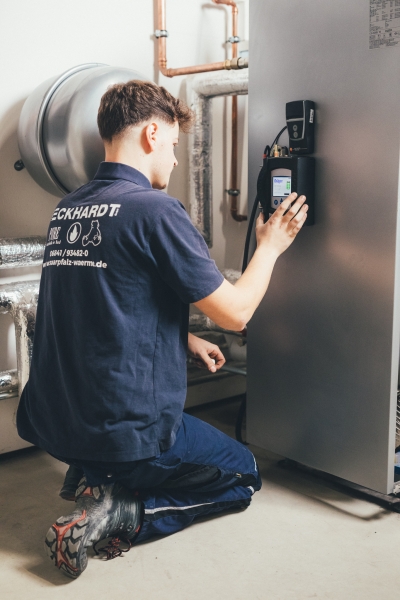 Techniker der Firma Eckhardt bedient Heizungssteuerung