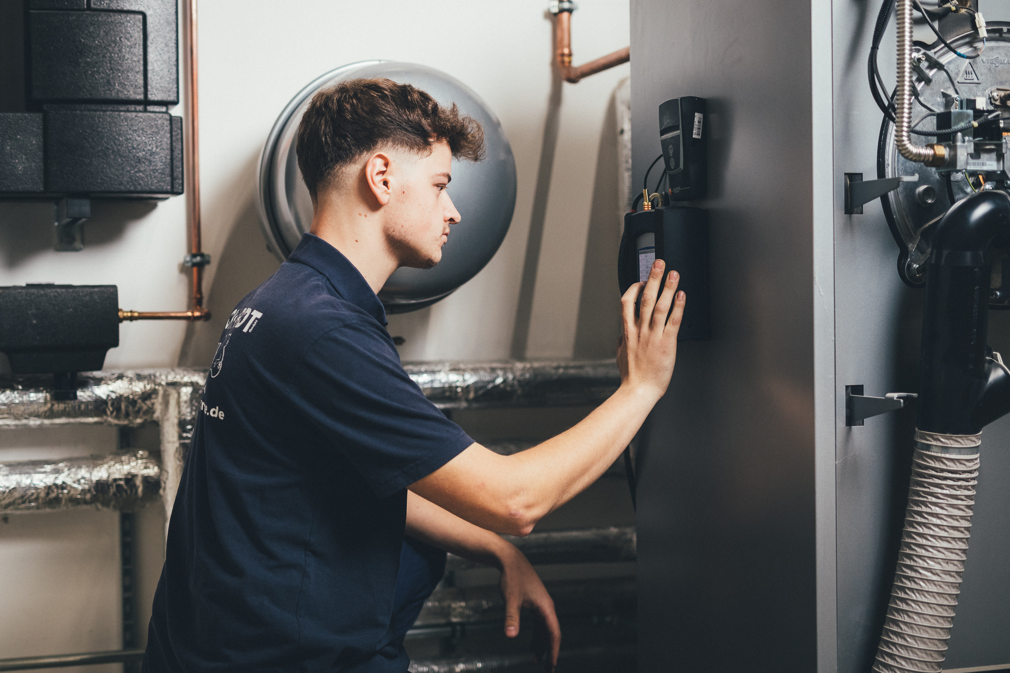 Mitarbeiter bedient moderne Heiztechnik im Technikraum