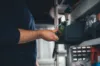 Hand greift Ersatzteil aus Regal im Lager