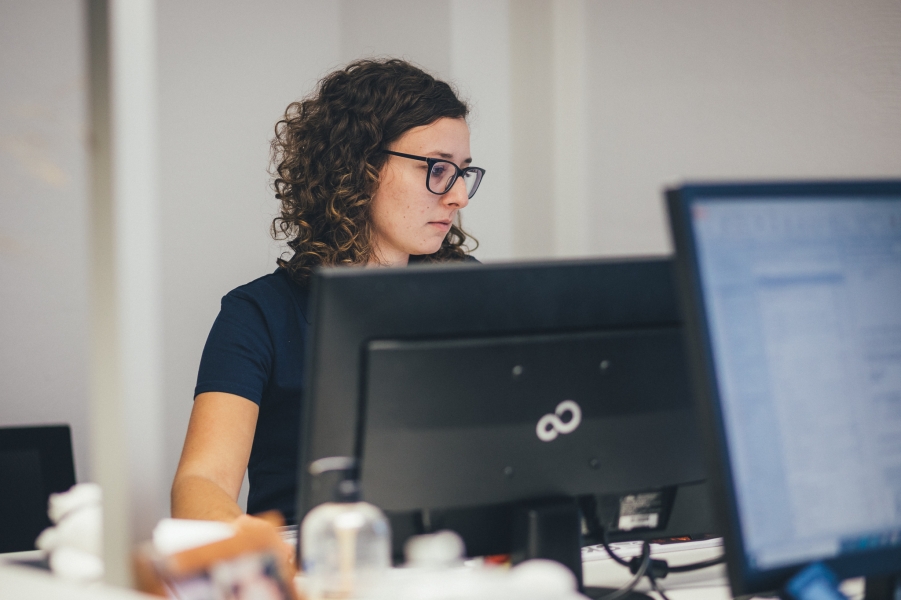 Mitarbeiterin arbeitet konzentriert am Computer