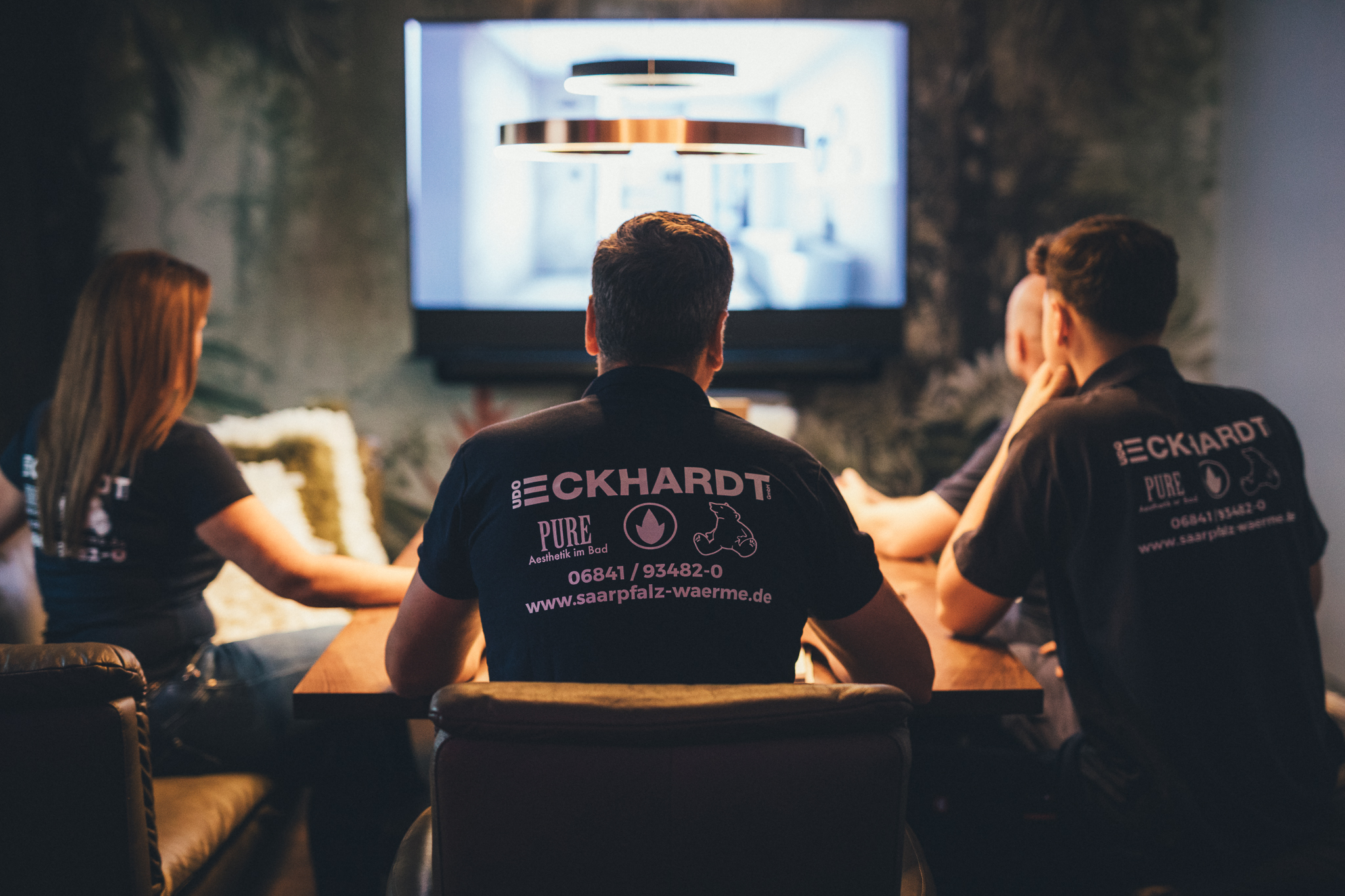Teammeeting bei Udo Eckhardt vor großem Bildschirm