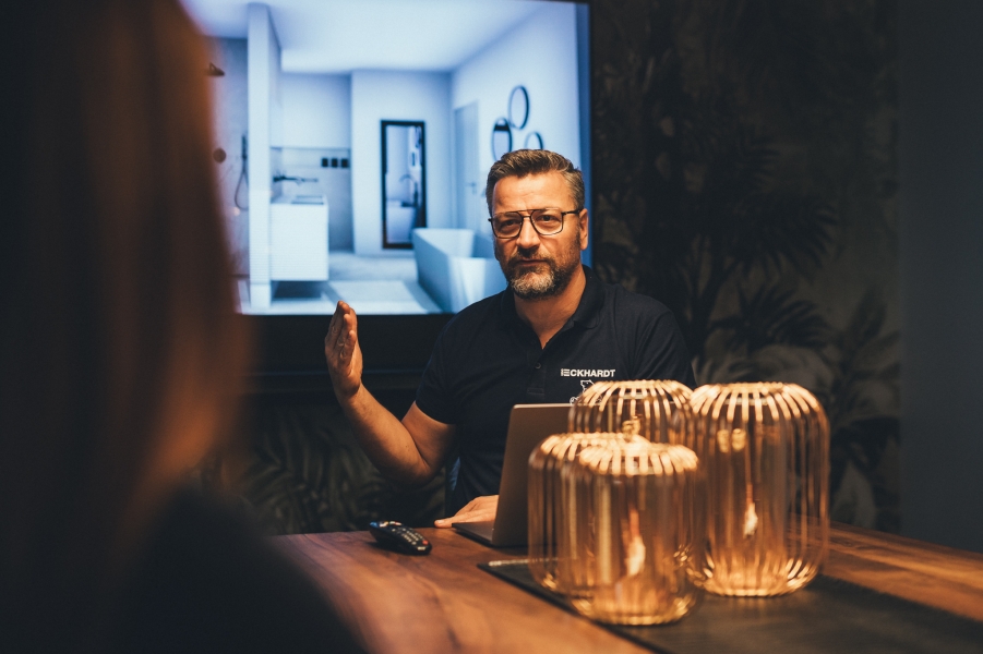 Mitarbeiter erklärt Badplanung am Bildschirm