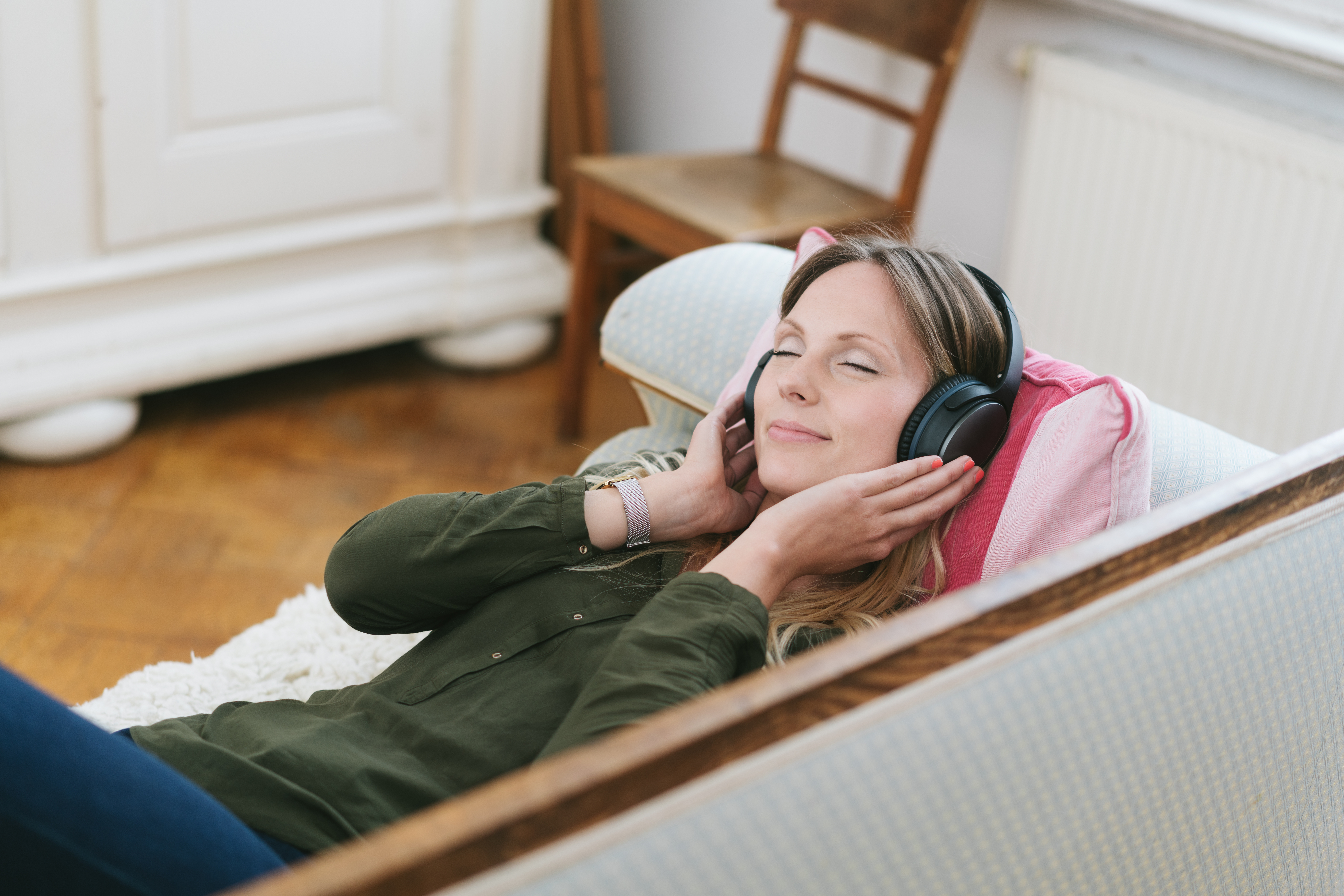 Frau entspannt auf Sofa mit Kopfhörern