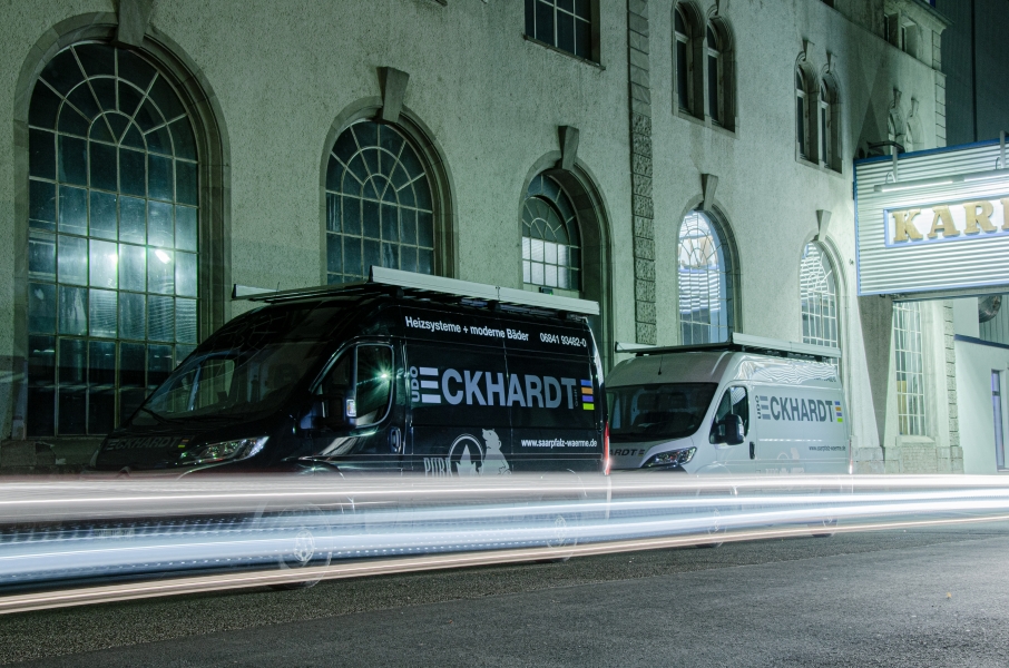 Zwei Eckhardt-Firmenfahrzeuge nachts vor Gebäude mit Lichtspuren