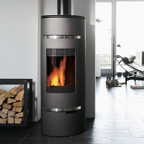 Schwarzer Kaminofen mit Holzlagerung und liegender Katze