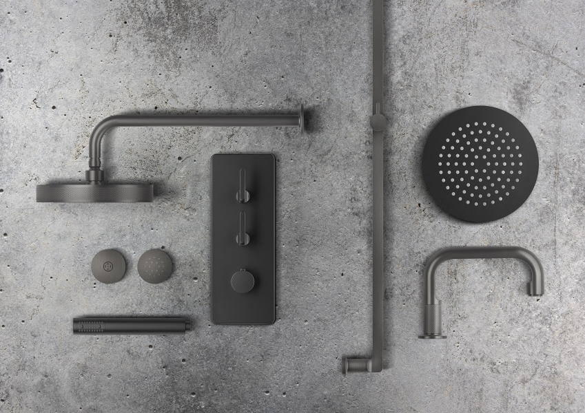 Dunkle Badarmaturen und Brausen auf Betonfläche arrangiert