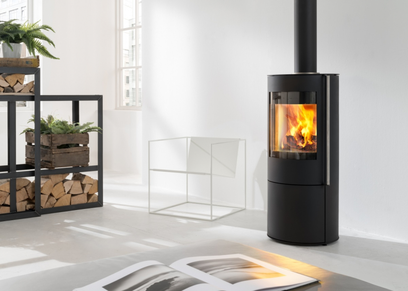 Schwarzer Kaminofen mit Feuer in heller, moderner Wohnumgebung