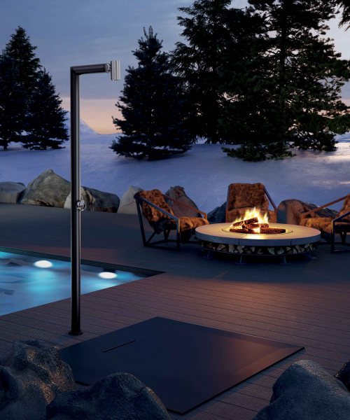 Außendusche bei Feuerstelle und Pool in winterlicher Abendstimmung