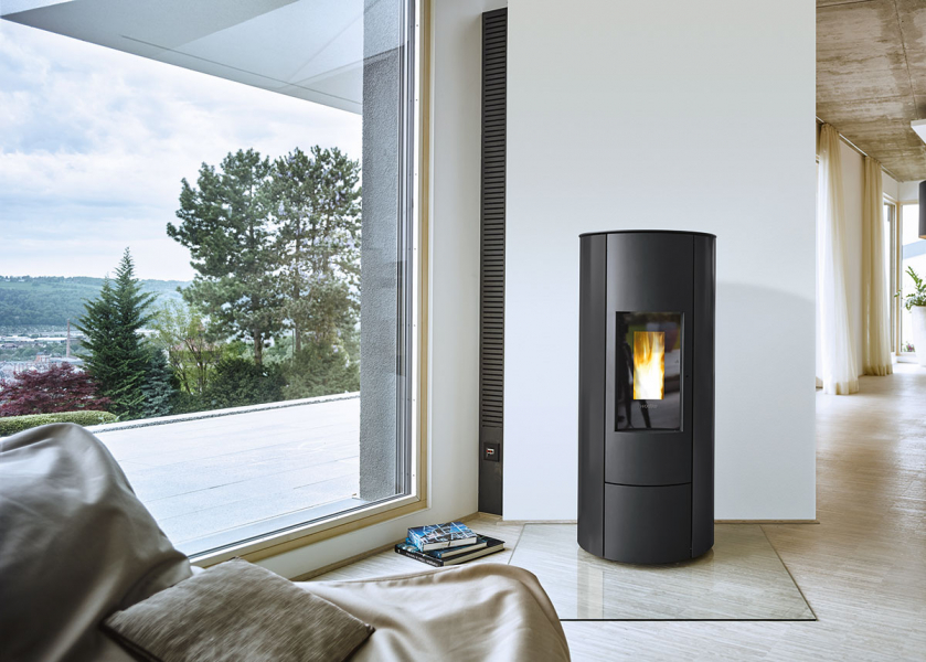 Runder Pelletofen vor großem Fenster