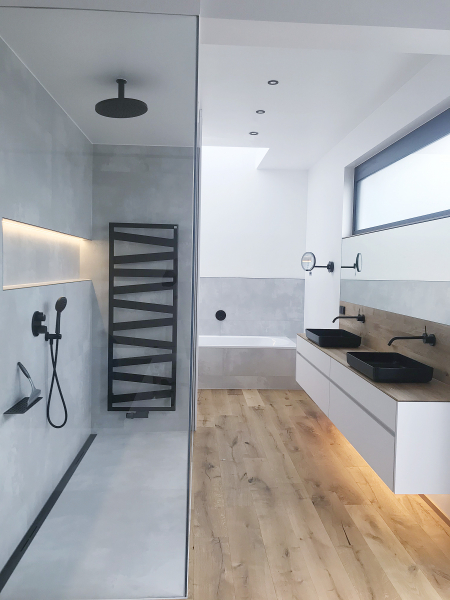 Helles Bad mit Glasdusche, schwarzen Armaturen und Holzfußboden