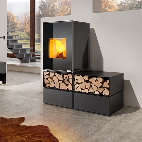 Kaminofen mit Holzablage vor großem Fenster mit Herbstblick