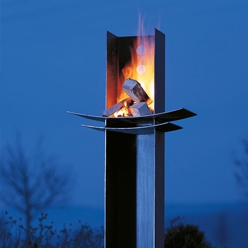 Moderne Feuerstelle mit Stahlrahmen bei Dämmerung