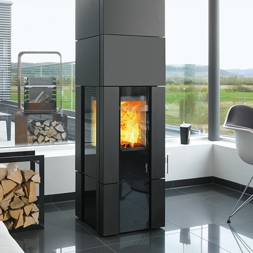 Hoher, eckiger Kamin mit Glasfront und Flammen in modernem Wohnraum