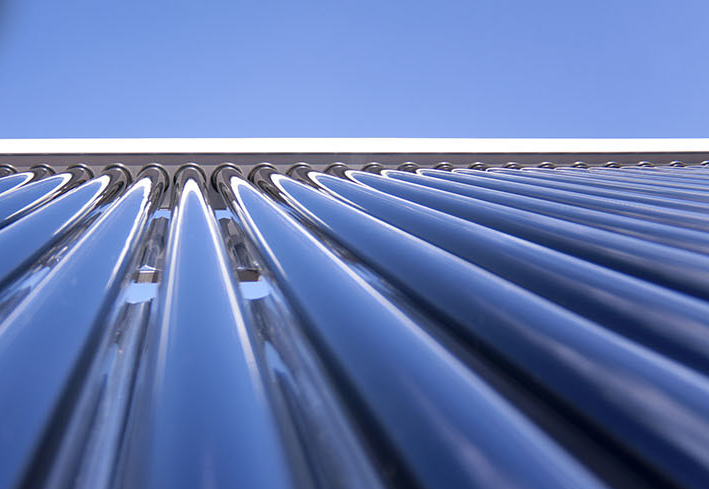 Nahaufnahme solarthermischer Röhrenkollektoren bei blauem Himmel