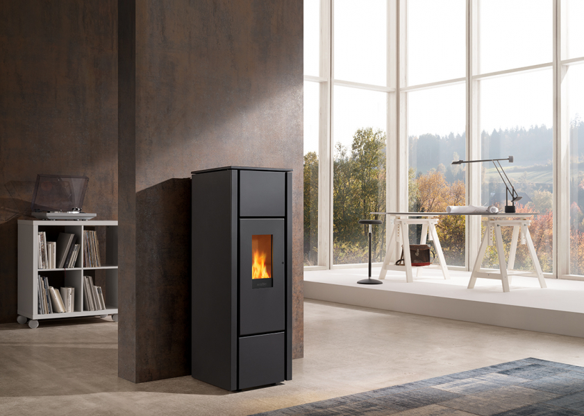 Schwarzer Pelletofen vor Betonwand