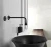 Schwarzes Waschbecken mit Wandarmatur in minimalistischer Umgebung