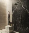Luxuriöse Dusche mit dunkler Marmorwand