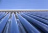 Nahaufnahme solarthermischer Röhrenkollektoren bei blauem Himmel