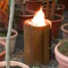 Runde Feuerstelle aus Stahl zwischen Blumentöpfen