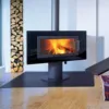 Moderner, schwarzer Kamin mit Sichtfenster und brennendem Feuerholz