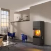Schwarzer Kaminofen mit Flamme, davor drei blaue Schafskulpturen